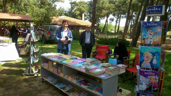 Το βιβλιοπωλείο Χαραλαμπίδη στην γιορτή με γεμάτο πάγκο από χρωματιστές εικόνες παραμυθιών και βιβλίων.